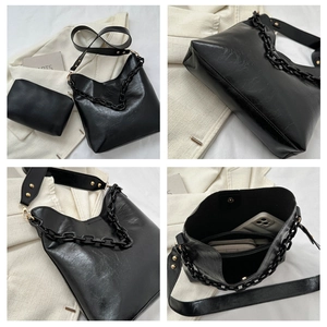Detail view of large black wax leather tote bag with acrylic chain and inner pouch