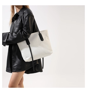 Detailed texture of white corduroy tote bag with durable black shoulder strap