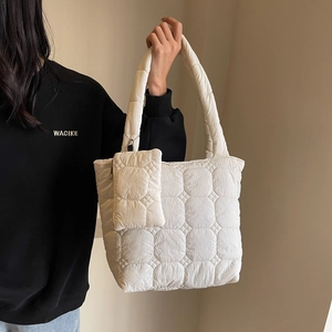 Fashionable off-white quilted tote bag with matching zippered pouch and soft handles