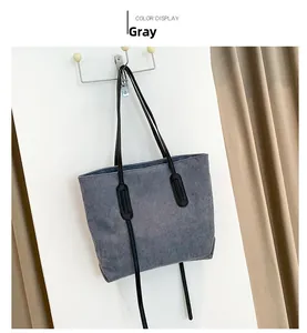 Detail of grey corduroy tote bag with vertical texture and slim black straps