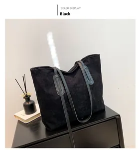 Detail of black corduroy tote bag with leather straps and spacious interior for daily use