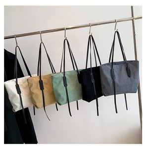 Detailed row of corduroy tote bags in five colors including cream white and mint green