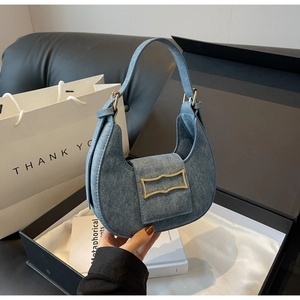 Grey-blue hobo bag with gold buckle displayed in a luxury black gift box with white silk