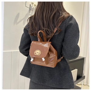 Brown mini backpack in glossy PU leather with cute dog patch shown on model's back