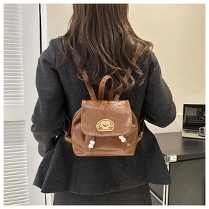 Brown faux leather mini backpack featuring a yellow cartoon dog embroidery and bead details