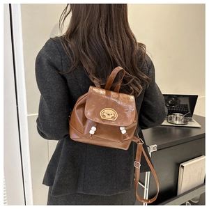 Detail of vintage brown faux leather mini backpack with cute dog embroidery and white beads