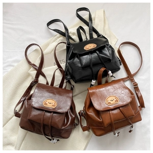 Detailed view of three mini PU leather backpacks with dog patches and drawstring closure