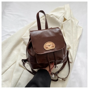 Detail of a brown mini faux leather backpack featuring a cute puppy embroidery patch