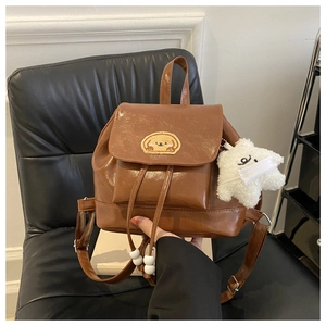 Detail of brown vintage mini backpack with glossy PU leather and cute dog patch
