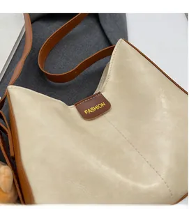 Detail of soft cream leather tote with brown strap stitching and fashion label logo