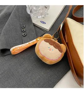 Close-up of plush girl charm with orange strap and Sweet lettering on leather bag