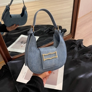 Chic light blue denim hobo bag with gold buckle hardware and a sleek half-moon silhouette