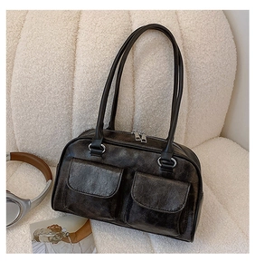 Detail of vintage PU leather tote bag with dual front pockets on white fleece