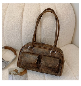 Retro brown PU leather tote bag with double pockets on a soft white sofa setting