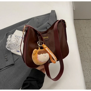 Detail of soft leather tote with FASHION lettering and a sweet plush ball pendant