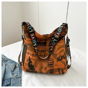 Detail der Totebag mit Zeitungsdruck und verstellbarem LOVE Buchstaben Schultergurt