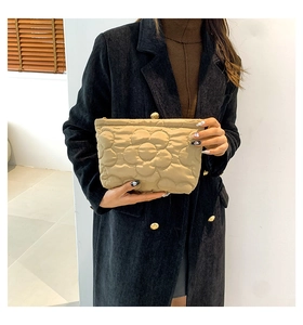 Detailopname van kaki gewatteerde clutch met bloemenpatroon en metalen ritssluiting