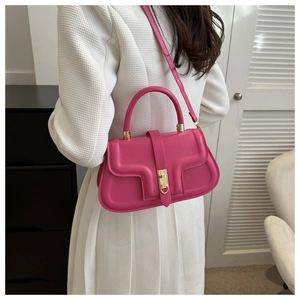 Vue lifestyle d'un sac à main en cuir magenta porté avec une robe plissée blanche