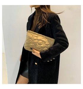 Detail van de kaki gewatteerde bucket clutch met bloemenborduursel en ritssluiting