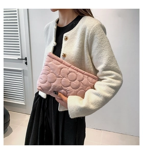 Detail van de roze gewatteerde handtas met zachte stof en het 3D-bloemstikpatroon