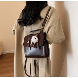 Rear view of model wearing a vintage dark brown leather backpack with contrast flap