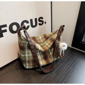 Detail of vintage plaid plush shoulder bag featuring soft texture and leather strap
