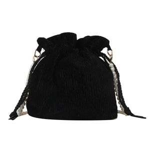 Minimalist black corduroy drawstring bucket bag with elegant pearl handle and vintage texture