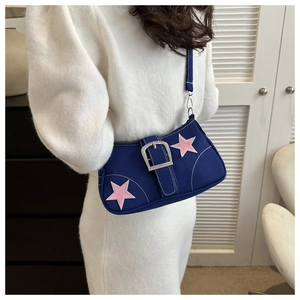 Detail of navy canvas underarm bag featuring pink star embroidery and silver buckle