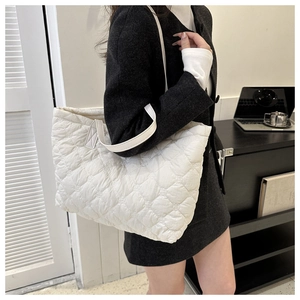 Close-up of ivory quilted puffer tote bag made of soft nylon fabric for women