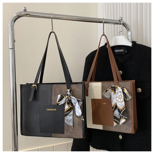 Close-up of matte PU leather tote bags with silk scarf handles and fashion print detail