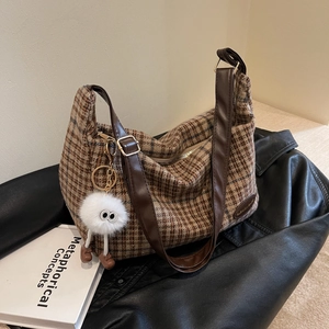 Retro brown plaid underarm bag with leather strap and plush monster pendant detail