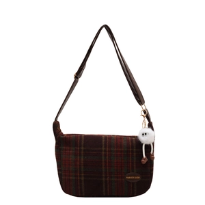 Retro plaid wool shoulder bag with leather strap and cute plush charm on white background