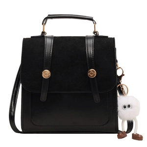 Vintage black crossbody handbag with matte paneling and cute white plush doll charm