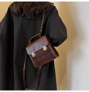 Close-up of vintage plaid briefcase bag on model showcasing texture and size
