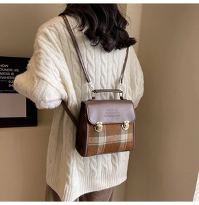 Close-up of vintage plaid backpack with leather flap and 'FANTASTIC' embossed detail