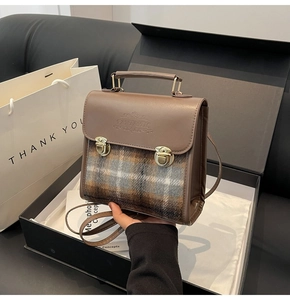 Detail of vintage briefcase with plaid fabric, metallic locks, and FANTASTIC embossed logo