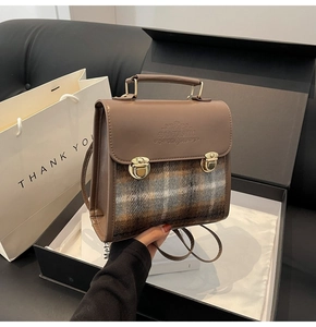 Detail of vintage patchwork briefcase with plaid fabric and embossed flap text