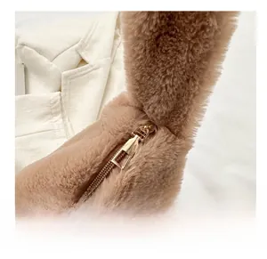 Detailed close-up of premium brown faux fur texture and smooth golden metal zipper on the bag