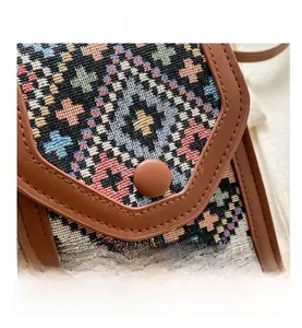 Détail du motif géométrique tissé et des finitions en cuir du sac à bandoulière