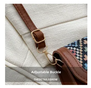 Détail d'une bandoulière en cuir avec boucle dorée sur un sac rétro à motif ethnique