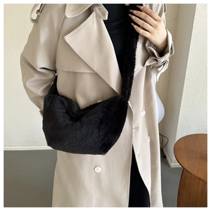 Detail of plush black dumpling crossbody bag featuring soft faux fur and wide shoulder strap