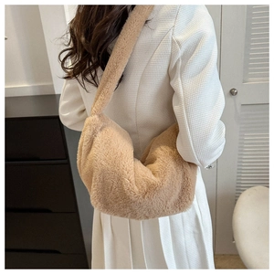 Detail of plush faux fur dumpling bag in apricot, featuring soft texture and wide shoulder strap
