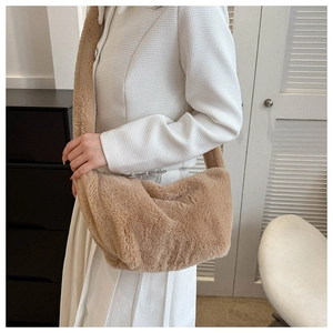 Close-up of brown plush faux fur crossbody bag worn with a white tweed coat and skirt