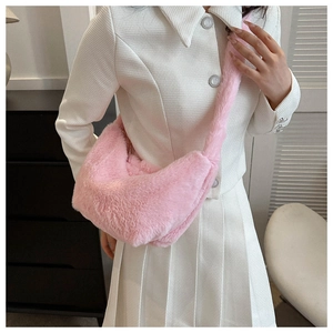 Close-up of fluffy pink faux fur dumpling bag worn with a white tweed jacket