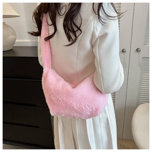Detailed view of pink plush crossbody bag with soft fuzzy texture and wide fuzzy strap