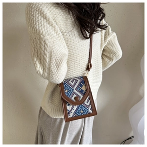 Détail du sac de téléphone tissé géométrique vintage avec bordure en cuir marron