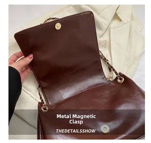Vue détaillée d'un sac vintage en cuir marron avec chaîne dorée et fermoir magnétique