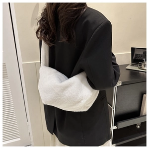 Close-up of white plush crossbody bag material worn by model over a black blazer