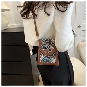 Détail du mini sac bandoulière vintage avec motif ethnique tissé et cuir synthétique brun