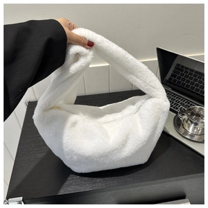 Detailed view of white plush faux fur crescent shoulder bag with golden zipper accent